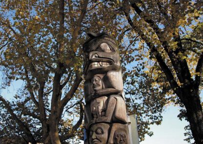 A totem pole against the trees.